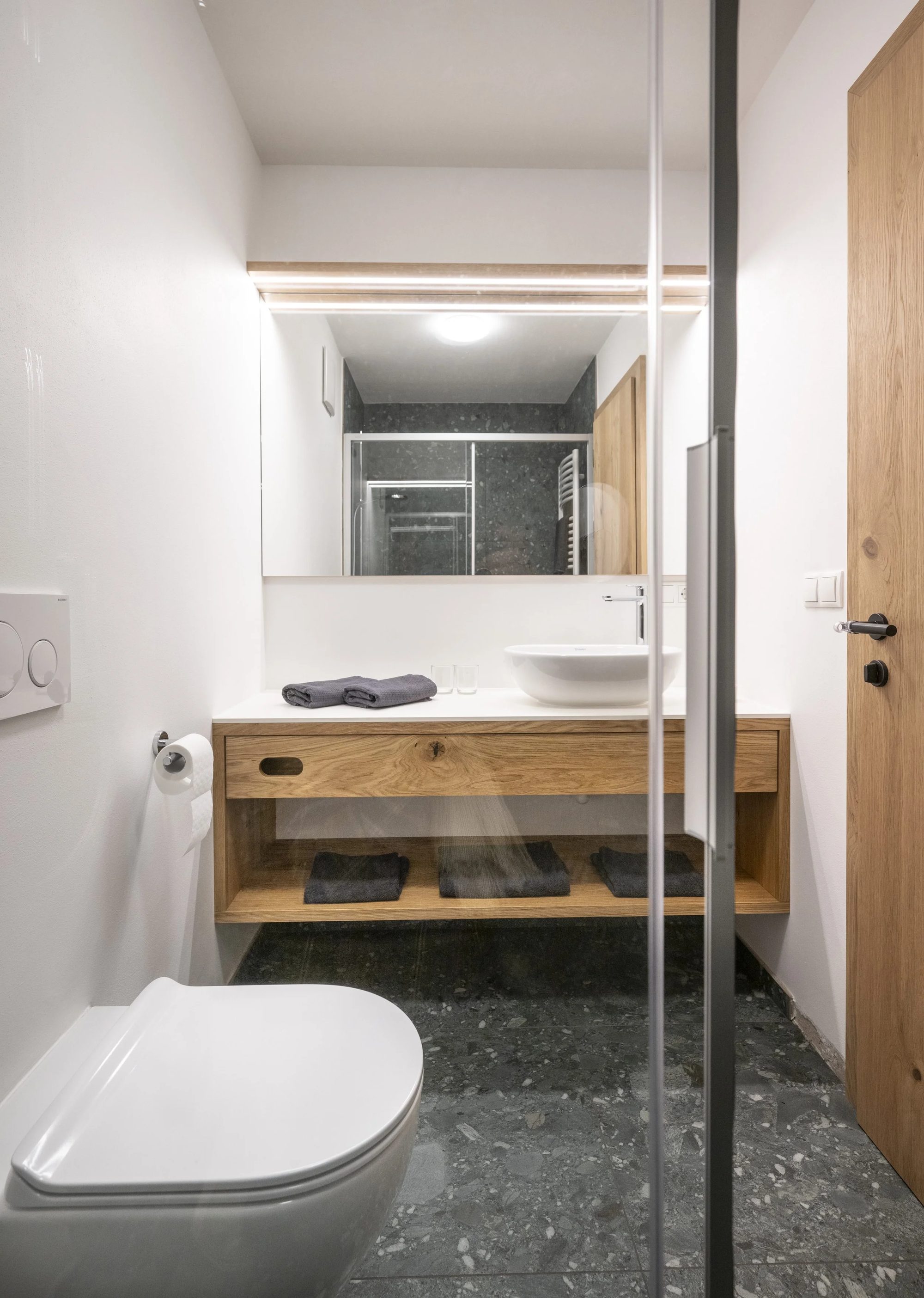 Modern bathroom with white walls and a large mirror