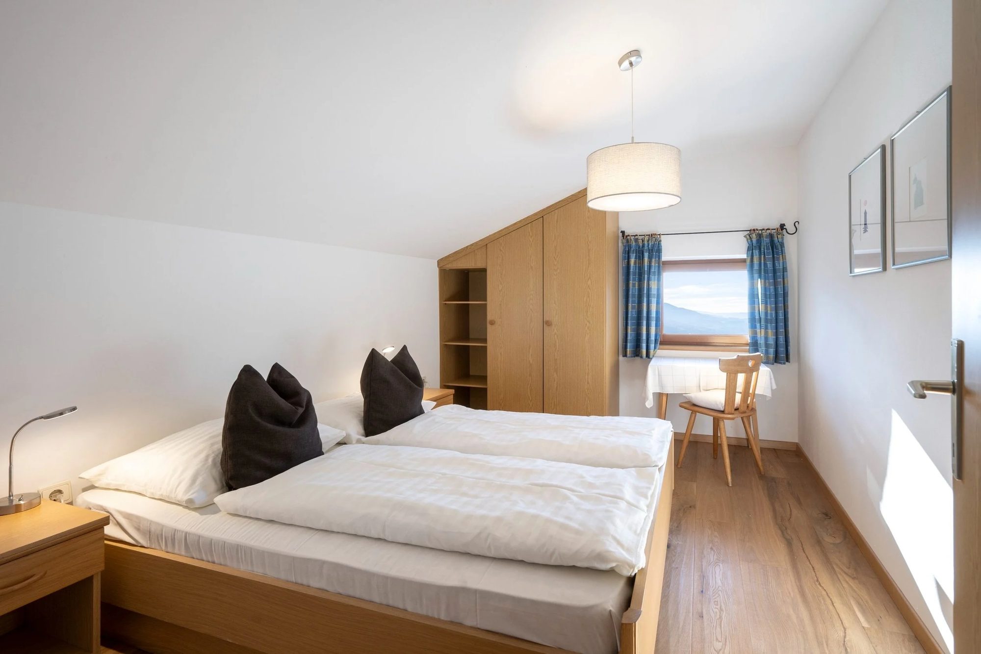 A bedroom with a wooden bed and white bedding