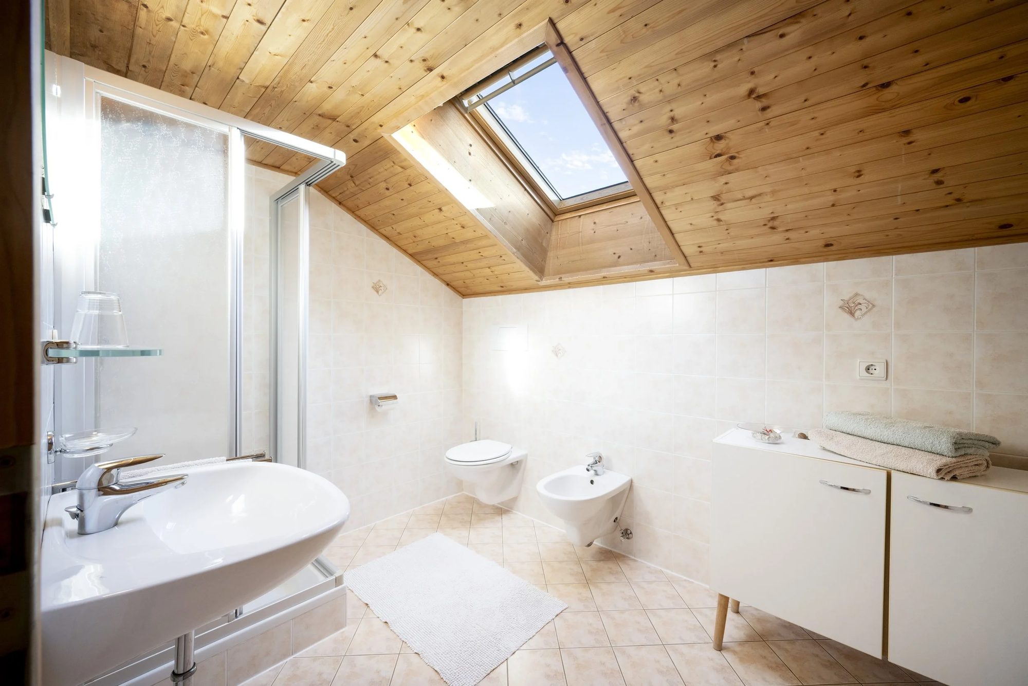 Bathroom with a wood-panelled sloped ceiling